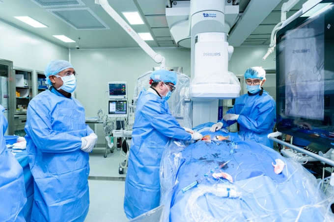 Giáo sư Nhân (giữa) luồn ống thông đến vị trí van động mạch chủ cần thay. Ảnh: Thanh Luận