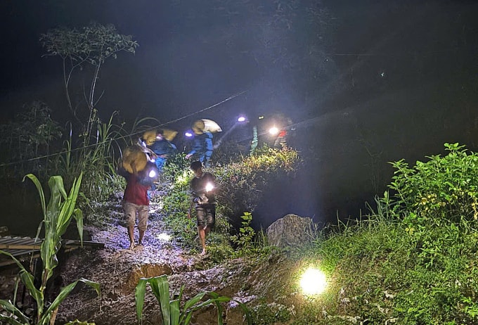 Lực lượng chức năng hỗ trợ người dân sơ tán tài sản khỏi nóc Kon Pin, đêm 20/10. Ảnh: Công an cung cấp