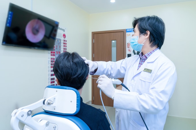 Bác sĩ Thái Duy đang nội soi tai cho anh Hải. Ảnh: Bệnh viện Đa khoa Tâm Anh