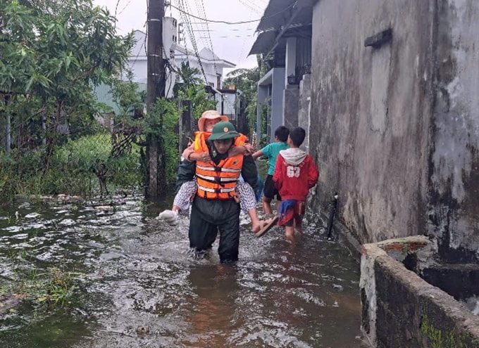 Chiến sĩ Biên phòng TP Huế hỗ trợ người dân đến nơi an toàn, ngày 22/10. Ảnh: BTL Biên phòng
