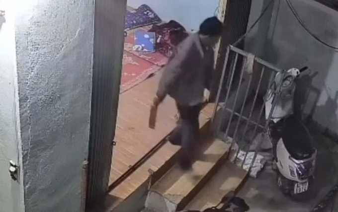 Người đàn ông cầm dao ra ngoài sau khi chém người ở xã Đăk Hà, tối 23/10. Ảnh camera an ninh