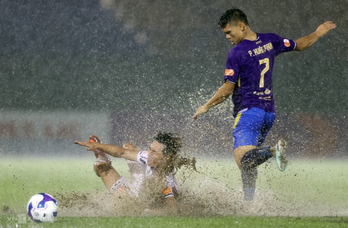 Cầu thủ CLB Becamex TP HCM và Hà Nội thi đấu trong mưa ở đầu trận tại vòng 8 V-League 2025-2026, tối 15/10. Ảnh: Đức Đồng