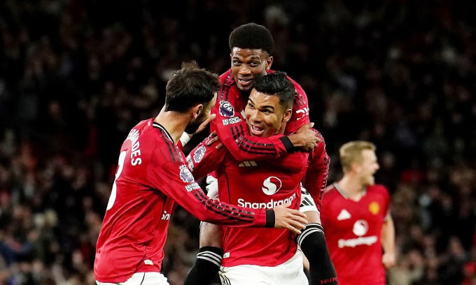 Casemiro cõng Amad mừng bàn thắng thứ hai cho Man Utd. Ảnh: PA