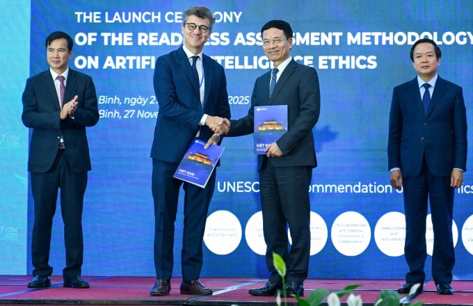 Bộ trưởng Nguyễn Mạnh Hùng nhận bàn giao biểu trưng Báo cáo Đánh giá Mức độ Sẵn sàng về Đạo đức trong Trí tuệ Nhân tạo từ đại diện UNESCO. Ảnh: Giang Huy