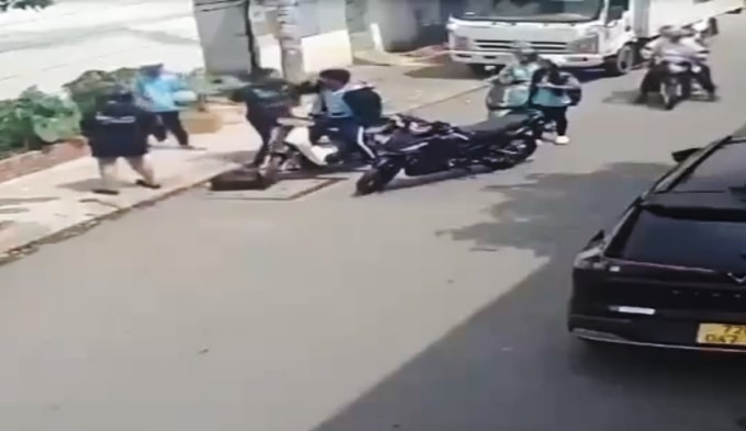 Camera ghi nhận nam thanh niên đang dùng nón bảo hiểm đánh học sinh ngồi trên xe. Ảnh: Cắt từ video