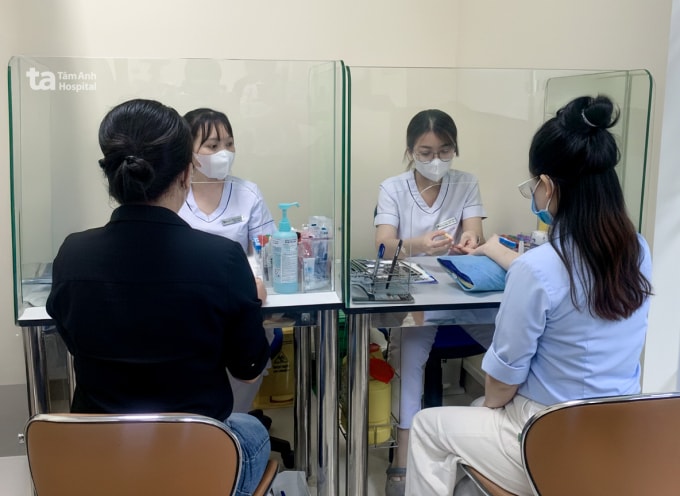 Chị Hoài và chị Thu (áo đen) được lấy máu xét nghiệm và kiểm tra đường huyết. Ảnh: Bệnh viện Đa khoa Tâm Anh