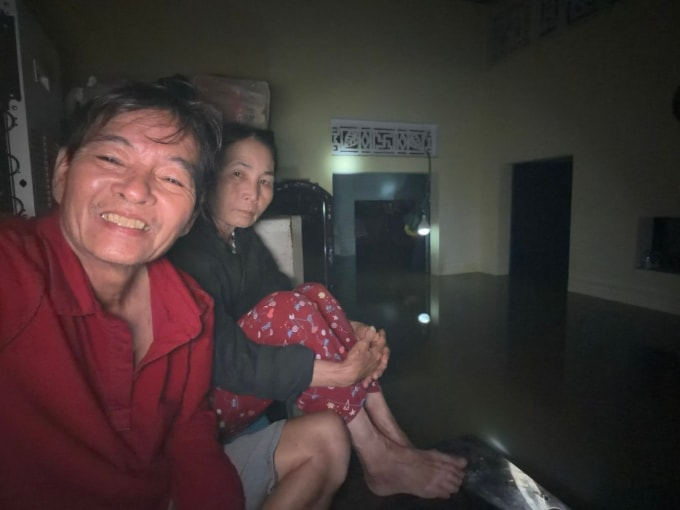 Vợ chồng ông Sum ngồi trên tủ để canh lũ. Ảnh: Nhân vật cung cấp