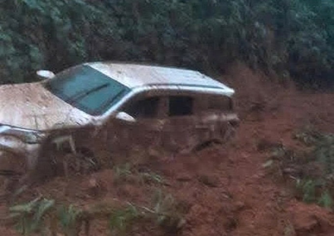 Chiếc xe 7 chỗ có hai người phía trong bị đất đá sạt lở vùi lấp. Ảnh: Nam Em