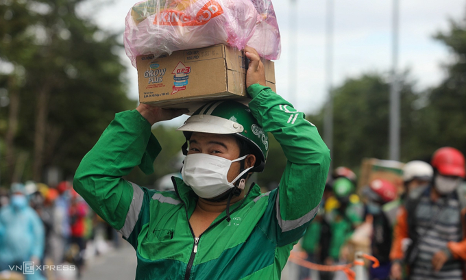 Shipper đứng xếp hàng chờ giao đồ trước bệnh viện dã chiến số 6, thời điểm dịch Covid-19. Ảnh: Thành Nguyễn