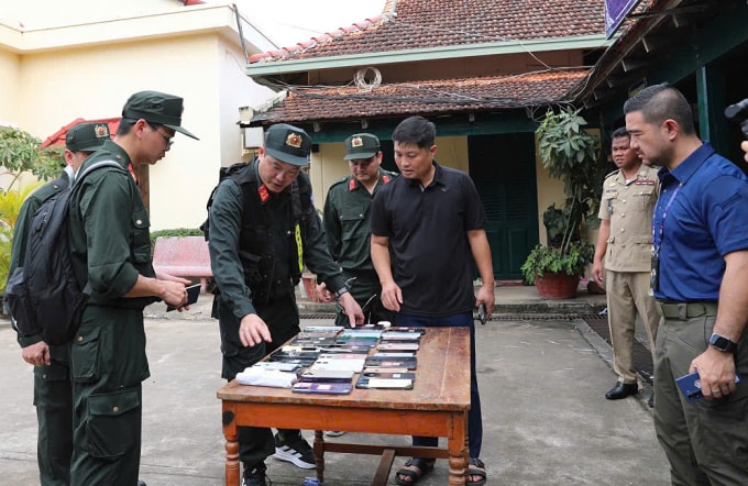 Công an kiểm kê tang vật lừa đảo qua mạng. Ảnh: Linh Đan