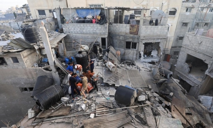 Nhân viên cứu hộ tìm kiếm nạn nhân từ đống đổ nát của một ngôi nhà bị hư hại do cuộc không kích trong đêm của Israel ở Gaza City ngày 29/10. Ảnh: Reuters