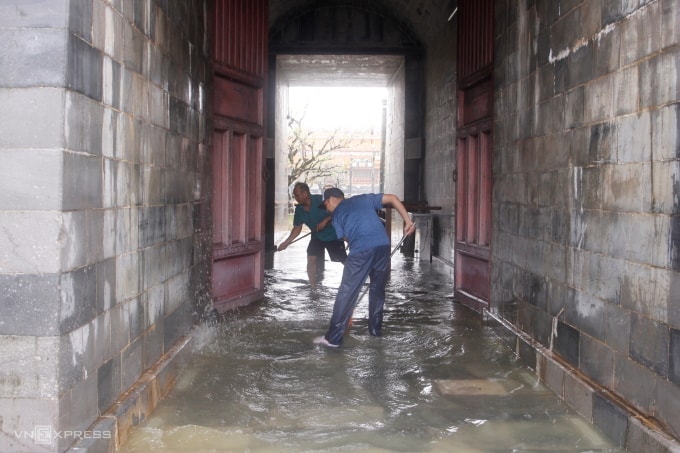 Bảo vệ di tích dọn lũ khi lũ rút. Ảnh: Võ Thạnh