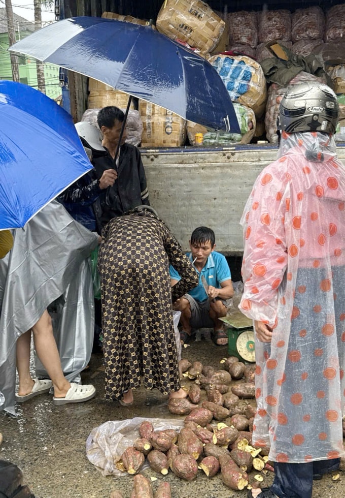 Chủ tài xế xe container từ Tây Nguyên bán rau củ tại thị trấn Khâm Đức trong khi mắc kẹt. Ảnh: Thanh Hải