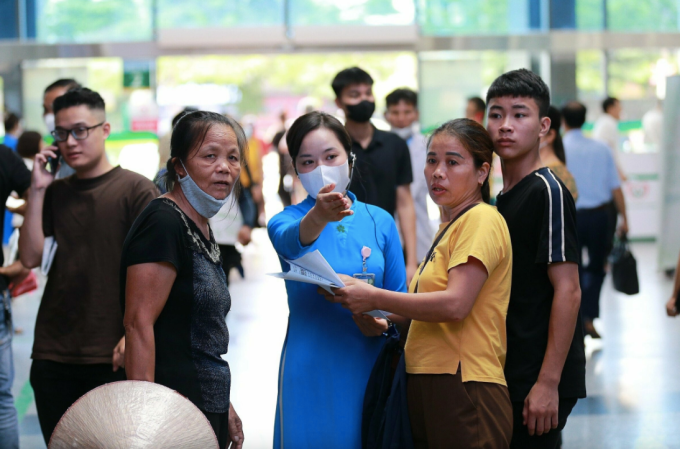 Nhân viên y tế Bệnh viện Bạch Mai hướng dẫn người dân làm thủ tục khám chữa bệnh. Ảnh:Thế Anh