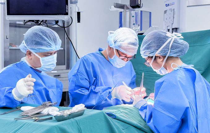 Bác sĩ Huân (giữa) cùng êkíp phẫu thuật cắt toàn bộ tuyến giáp cho bệnh nhân Lộc. Ảnh: Bệnh viện Đa khoa Tâm Anh