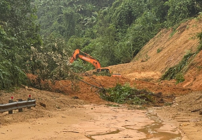 Xe xúc đang dọn điểm sạt lở trên cầu Đăk Ét, sáng 30/10. Ảnh: Minh Tuân