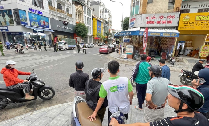 Người dân hiếu kỳ theo dõi cảnh sát khám xét. Ảnh: Lam Sơn