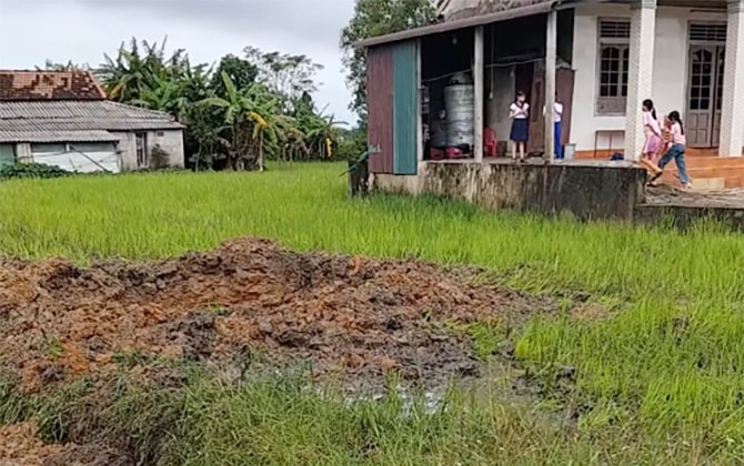 Vụ nổ tạo hố sâu trên ruộng. Ảnh: Đông Xuân