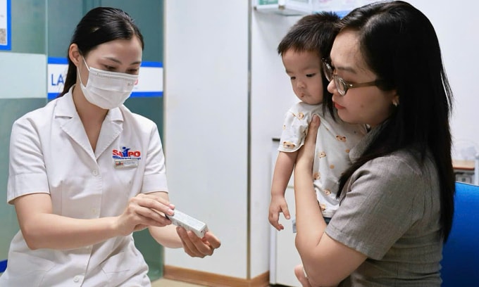 Trẻ đi tiêm phòng cúm mùa. Ảnh: Thi Ngân