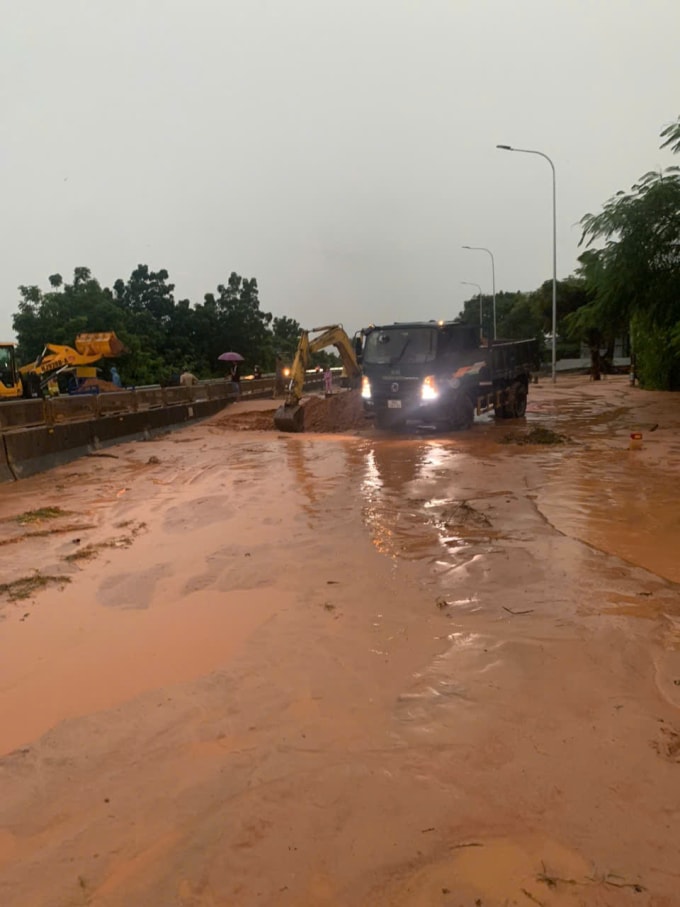 Xe mú, xe ben đang xử lý di chuyển cát đỏ ra khỏi quốc lộ 1. Ảnh: khải Nguyên