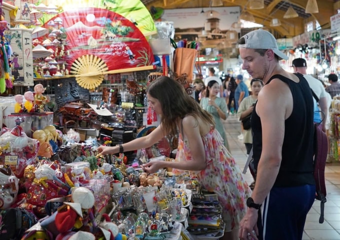 Du khách tìm mua đồ lưu niệm trong chợ Bến Thành. Ảnh: Tuấn Anh