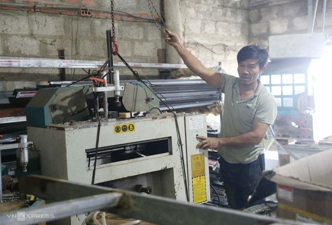 Ông Thắng dùng ròng rọc đưa máy móc của xưởng cơ khí lên cao. Ảnh: Đắc Thành