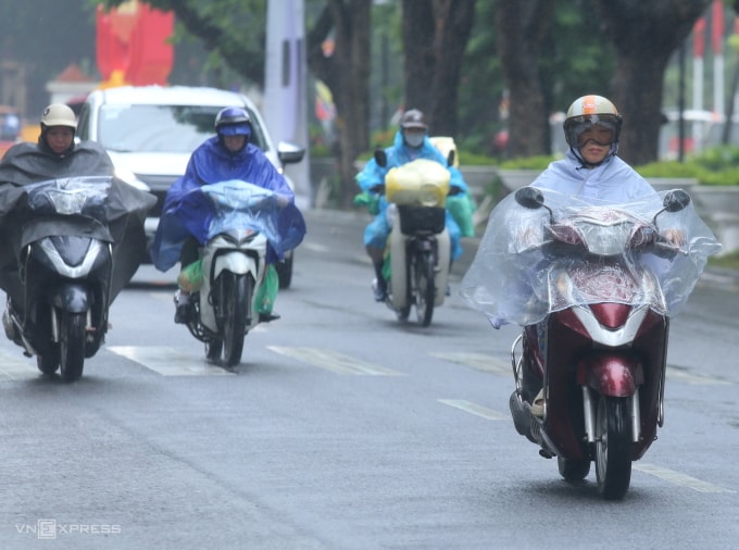 Người Hà Nội tham gia giao thông trong mưa lạnh. Ảnh: Gia Chính