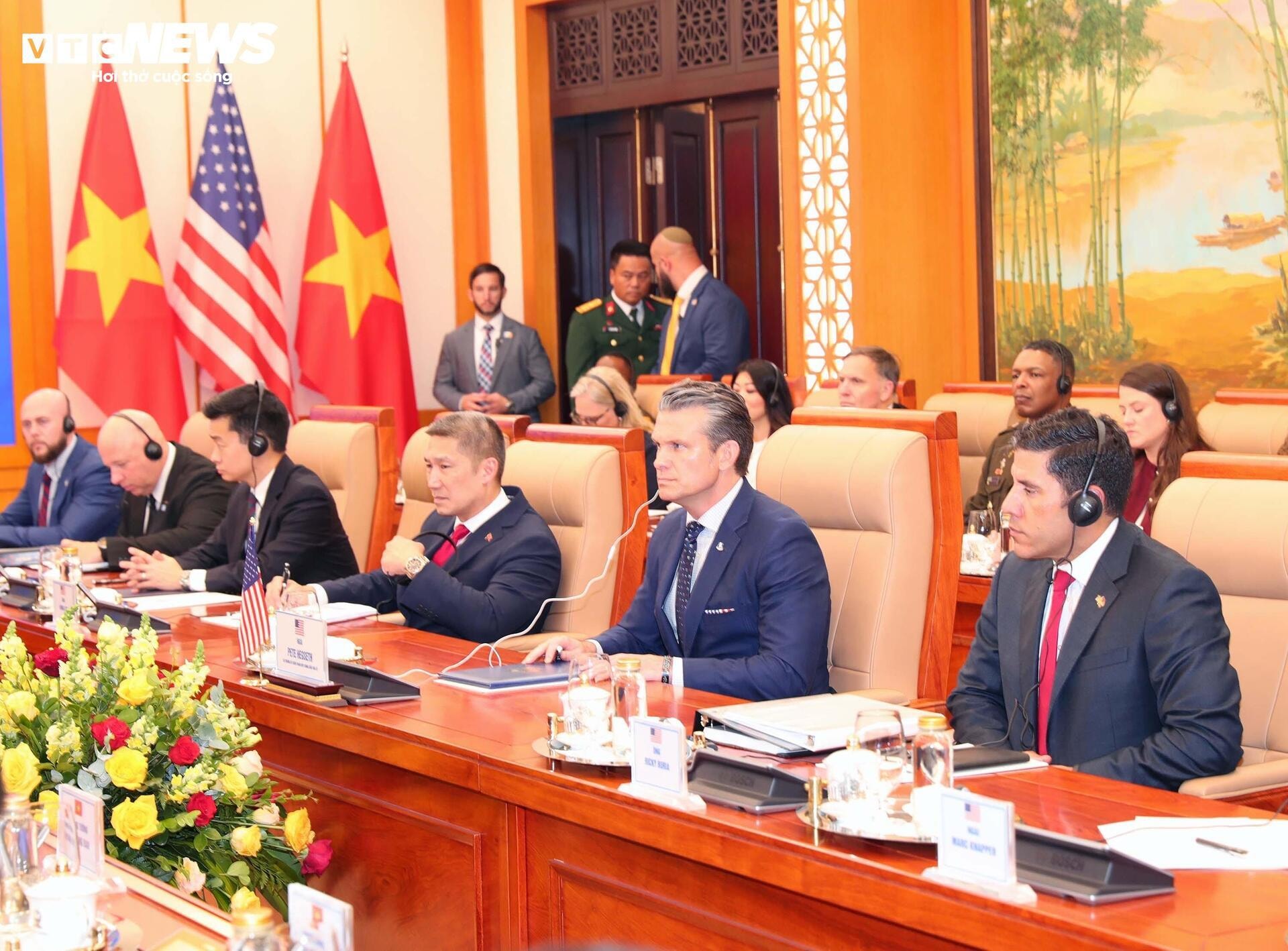 Thứ trưởng Hải quân Mỹ Hùng Cao (hàng đầu, thứ ba từ phải sang) tháp tùng Bộ trưởng Chiến tranh Pete Hegseth (hàng đầu, thứ hai từ phải sang) trong chuyến thăm chính thức Việt Nam tại Hà Nội, ngày 2/11/2025.