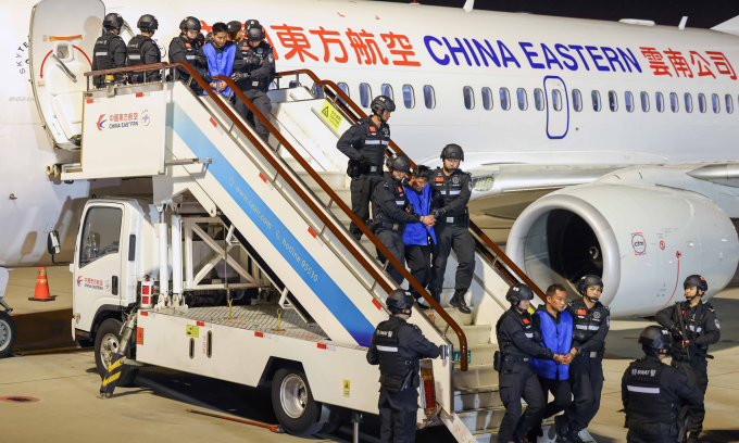 Cảnh sát Trung Quốc áp giải nghi phạm lừa đảo từ Myanmar xuống sân bay tại thành phố Côn Minh năm 2024. Ảnh: AFP