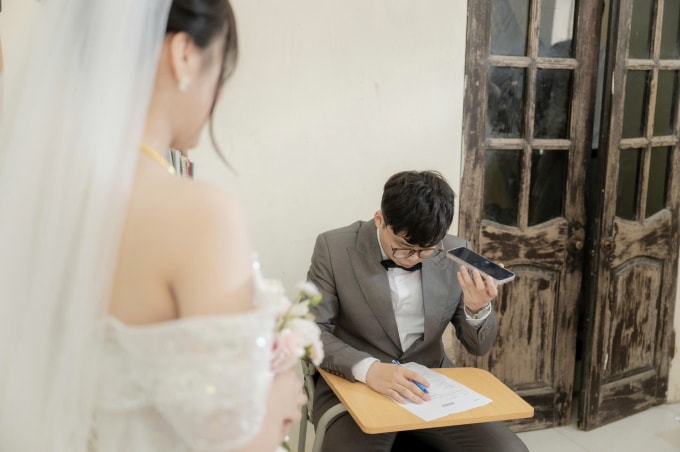 Chú rể Nhật Ninh chăm chú nghe và giải đề thi tiếng Anh trước lúc đón dâu tại xã Tam Hưng, Hà Nội, sáng 16/10. Ảnh: Nhân vật cung cấp