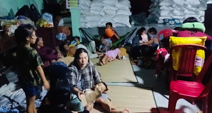 Chị Đào (áo kẻ) và các con ở nơi tránh bão tại nhà văn hóa Thạnh Đức 2 (phường Sa Huỳnh), tối 6/11. Ảnh: Trần Quyết