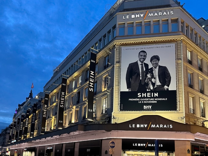 Quảng cáo Shein tại trung tâm thương mại BHV vớihình Chủ tịch SGM Frédéric Merlin (bên trái), Chủ tịch điều hành Shein Donald Tang và chú chó Satchi. Ảnh: Reuters