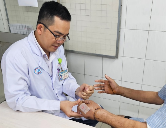 Bác sĩ kiểm tra tay bệnh nhân trước khi xuất viện ngày 6/11. Ảnh: Bệnh viện cung cấp