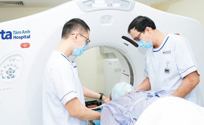 Kỹ sư thực hiện mô phỏng điều trị bằng hệ thống CT và mặt nạ cố định vùng đầu cho người bệnh. Ảnh: Bệnh viện Đa khoa Tâm Anh