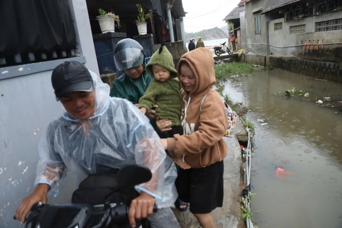 Anh Trần Văn Độ gom đồ đạc, chở vợ con di tản khi căn nhà nằm ở chân núi Cấm có nguy cơ bị sạt lở nguy hiểm trong bão. Ảnh: Đình Văn