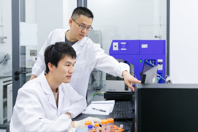 Hai nhà nghiên cứu khoa học tại Trung tâm Hạ tầng Sinh học Tổng hợp Thâm Quyến, tỉnh Quảng Đông, Trung Quốc ngày 27/3. Ảnh: AFP