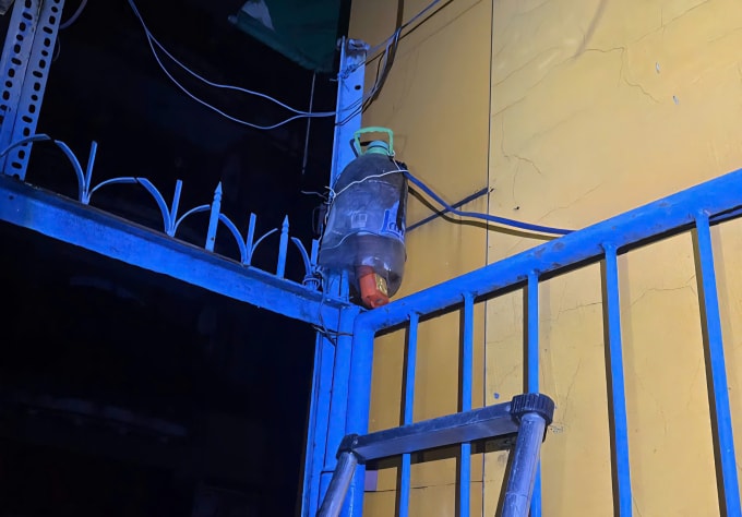 Ổ cắm gắn trên hàng rào của cửa hàng tiện lợi bị nghi ngờ rò rỉ điện xuống vùng nước ngập. Ảnh: Minh Bằng