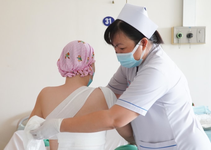 Điều dưỡng thay băng cho bệnh nhân sau mổ. Ảnh: Bệnh viện cung cấp