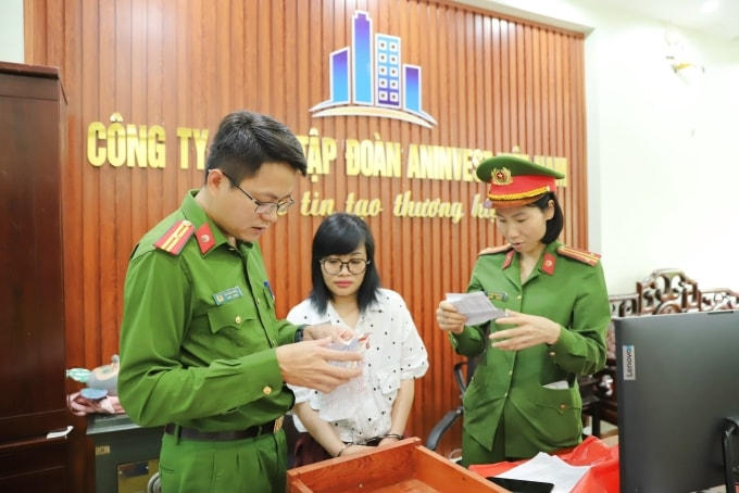 Công an khám xét trụ sở công ty trước sự chứng kiến của kế toán Nguyễn Thị Phương. Ảnh: Công an cung cấp