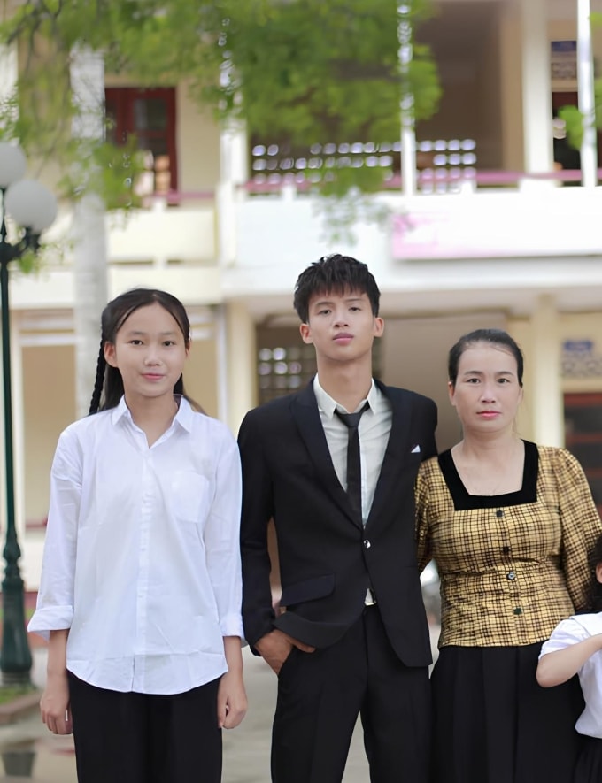 Chị Huệ bên hai con, trong lễ tốt nghiệp cấp ba của con trai, năm 2024. Ảnh gia đình cung cấp