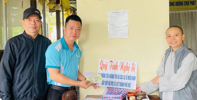 Nhóm tình nguyện viên thay mặt Đàm Vĩnh Hưng hỗ trợ tiền cho bà con ở Huế. Ảnh: Nhân vật cung cấp