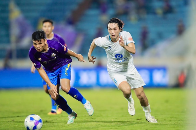 Hậu vệ Hà Nội FC Phạm Xuân Mạnh (trái) tranh chấp với tiền vệ Nam Định Nguyễn Tuấn Anh. Ảnh: Quang Đương