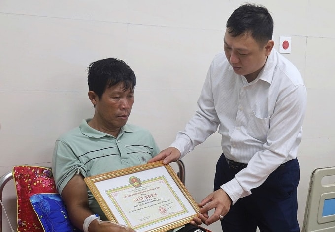 Chủ tịch đặc khu Lý Sơn Nguyễn Văn Huy (phải) trao giấy khen cho ông Phan Duy Quang. Ảnh: Nam Thanh