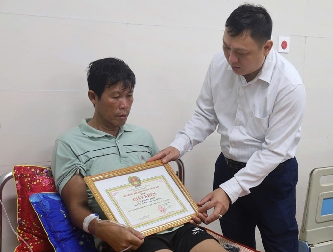 Chủ tịch đặc khu Lý Sơn Nguyễn Văn Huy (phải) trao giấy khen cho ông Phan Duy Quang. Ảnh: Nam Thanh