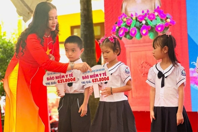 Học sinh hoàn cảnh khó khăn Trường Tiểu học số 2 Bắc Ly nhận quà là thẻ bảo hiểm y tế. Ảnh: Minh Anh