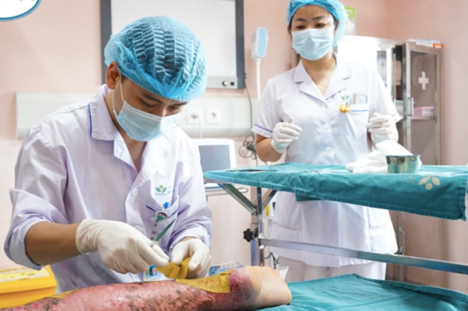 Bác sĩ chăm sóc vết thương bỏng ở vùng chân cho bệnh nhi. Ảnh: Bệnh viện cung cấp