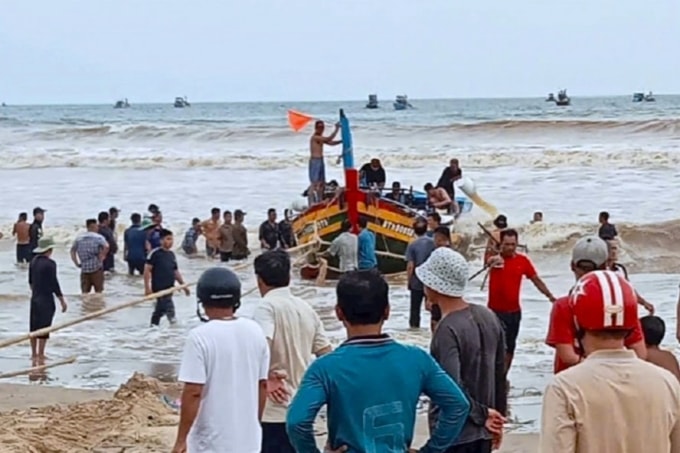 Ngư dân trục vớt kéo tàu gặp nạn vào bờ ở biển La Gi. Ảnh: Tân Hải