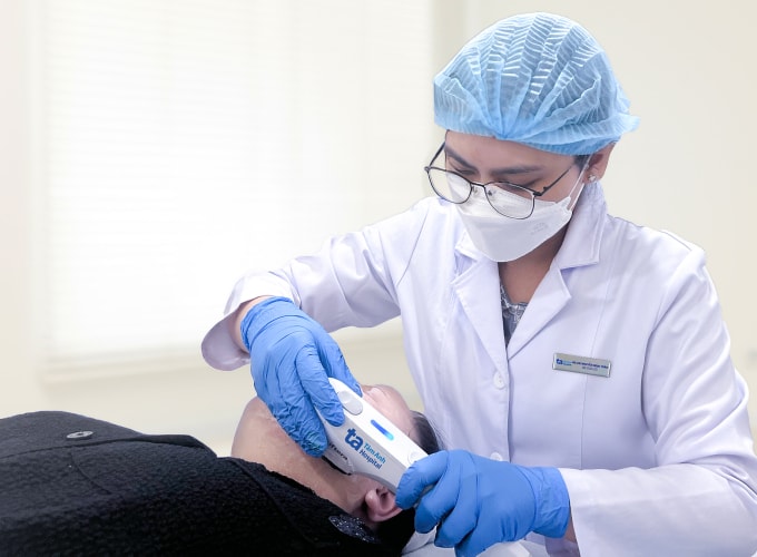 Bác sĩ sử dụng sóng siêu âm hội tụ để săn chắc vùng cằm cho chị Thu. Ảnh: Bệnh viện Đa khoa Tâm Anh