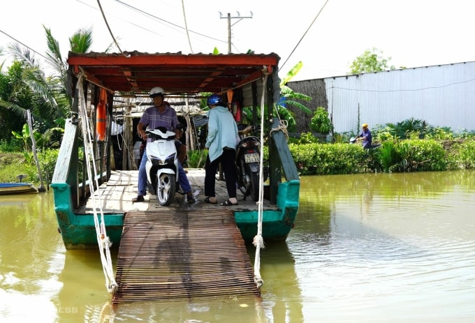Người dân qua phà tại kênh Bà Phương khi cầu đang đổ móng. Ảnh: Chúc Ly
