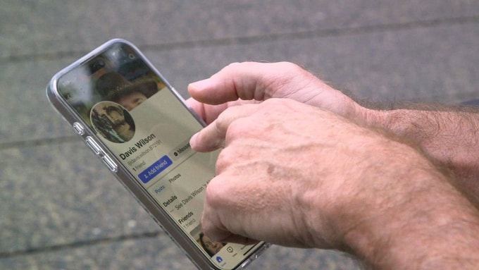 Scott Cole chỉ ra một trang cá nhân trên Facebook sử dụng tên Davis Wilson cùng với những bức ảnh thật của ông. Ảnh: ABC